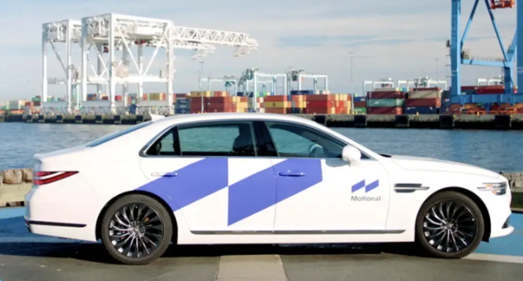A white car is parked in front of a container ship, showcasing unique categories in our portfolio.