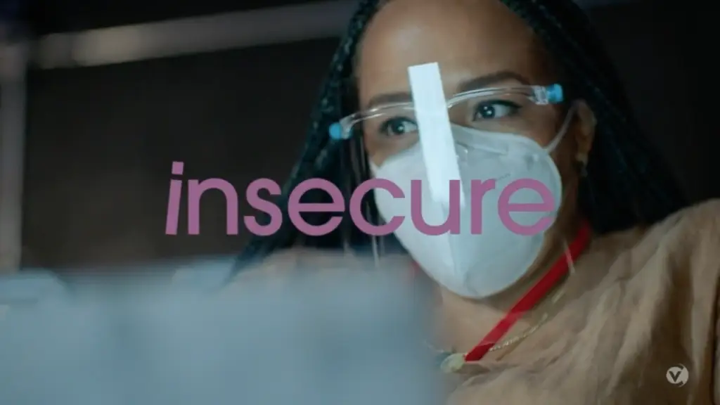 A woman wearing a mask with the word insecure on it.
