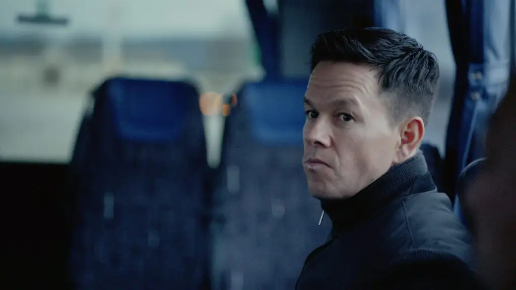 A man in a black jacket sitting on a bus.