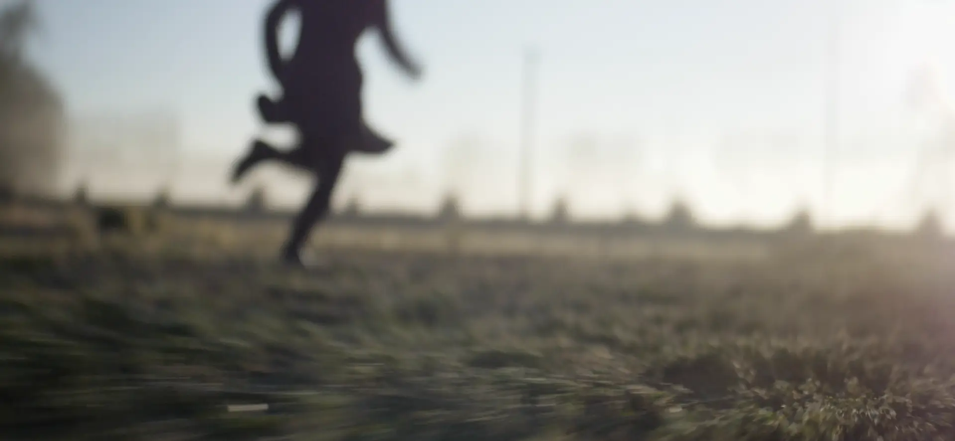 A woman is running on a grassy field, featuring entertainment.