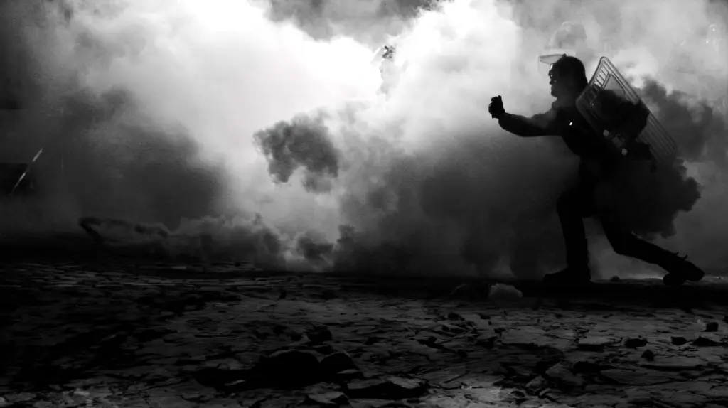 A branded black and white photo of a man running through smoke, LIVE 2023.