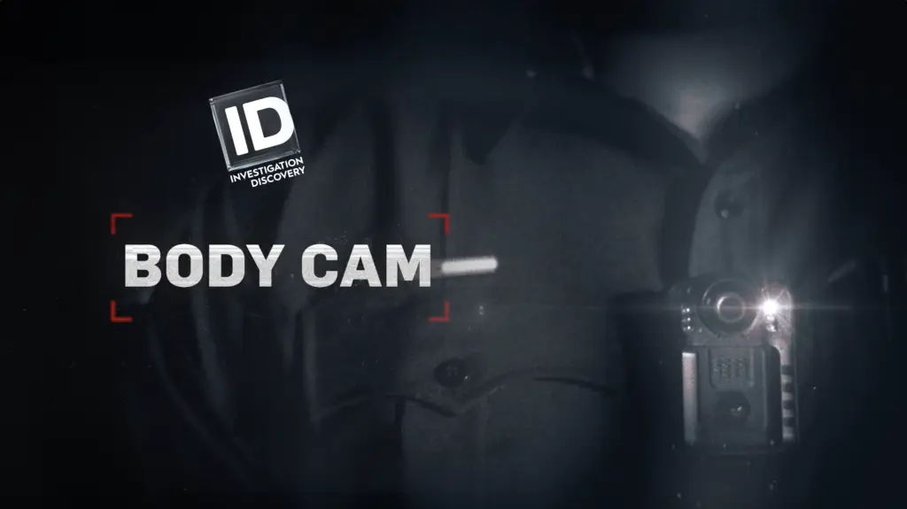 A police officer is holding a body cam in front of a dark background, immersed in true crime work.