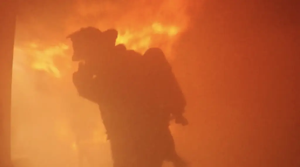 A silhouette of a firefighter standing in front of a raging fire, an essential keyword for SEO.