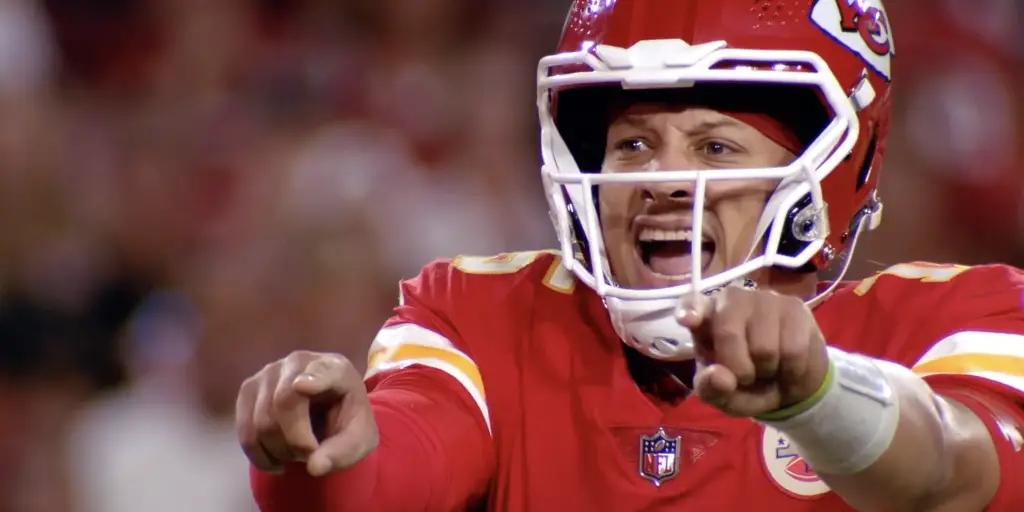 An entertainment Kansas Chiefs football player is pointing his finger.