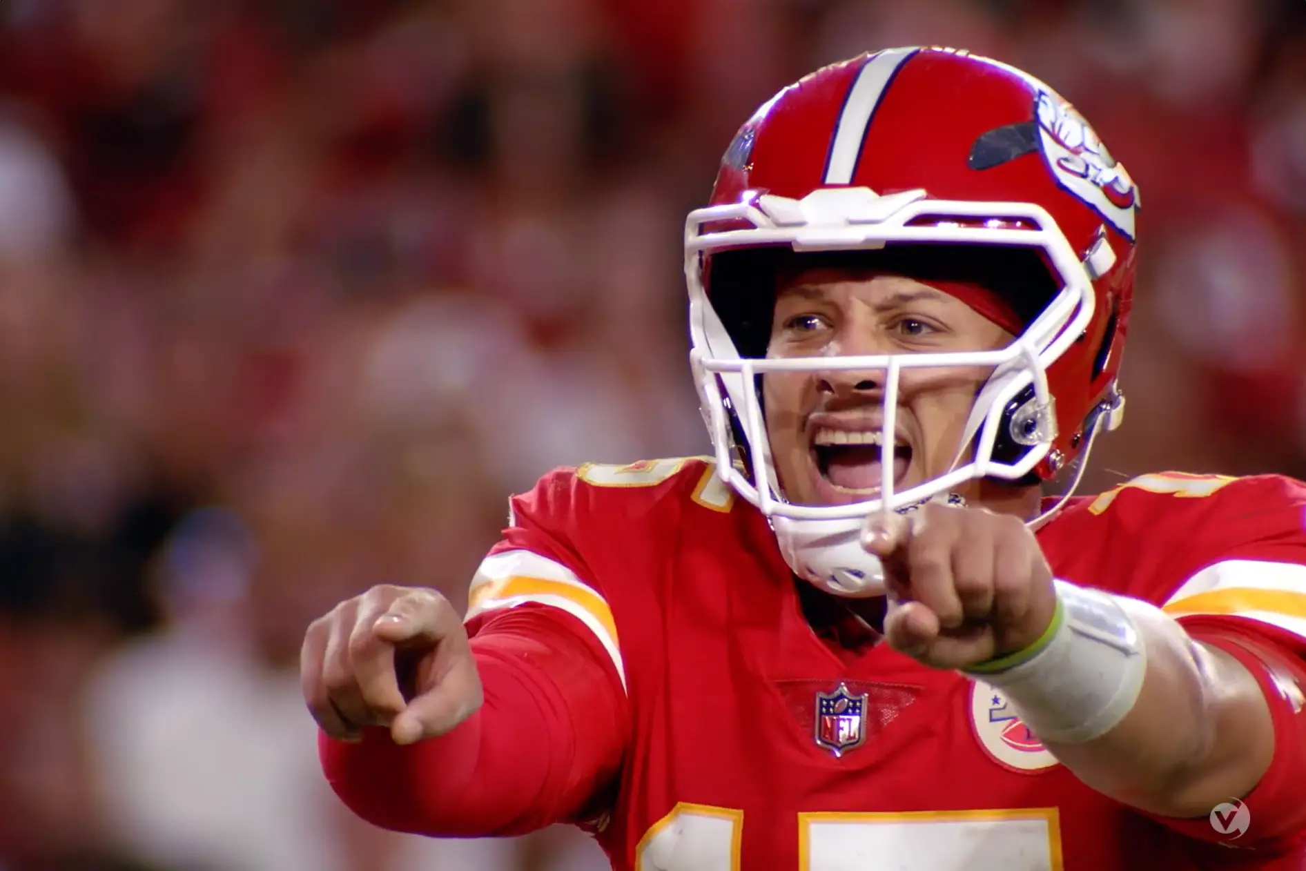 A Kansas Chiefs football player is pointing his finger during an entertainment event.