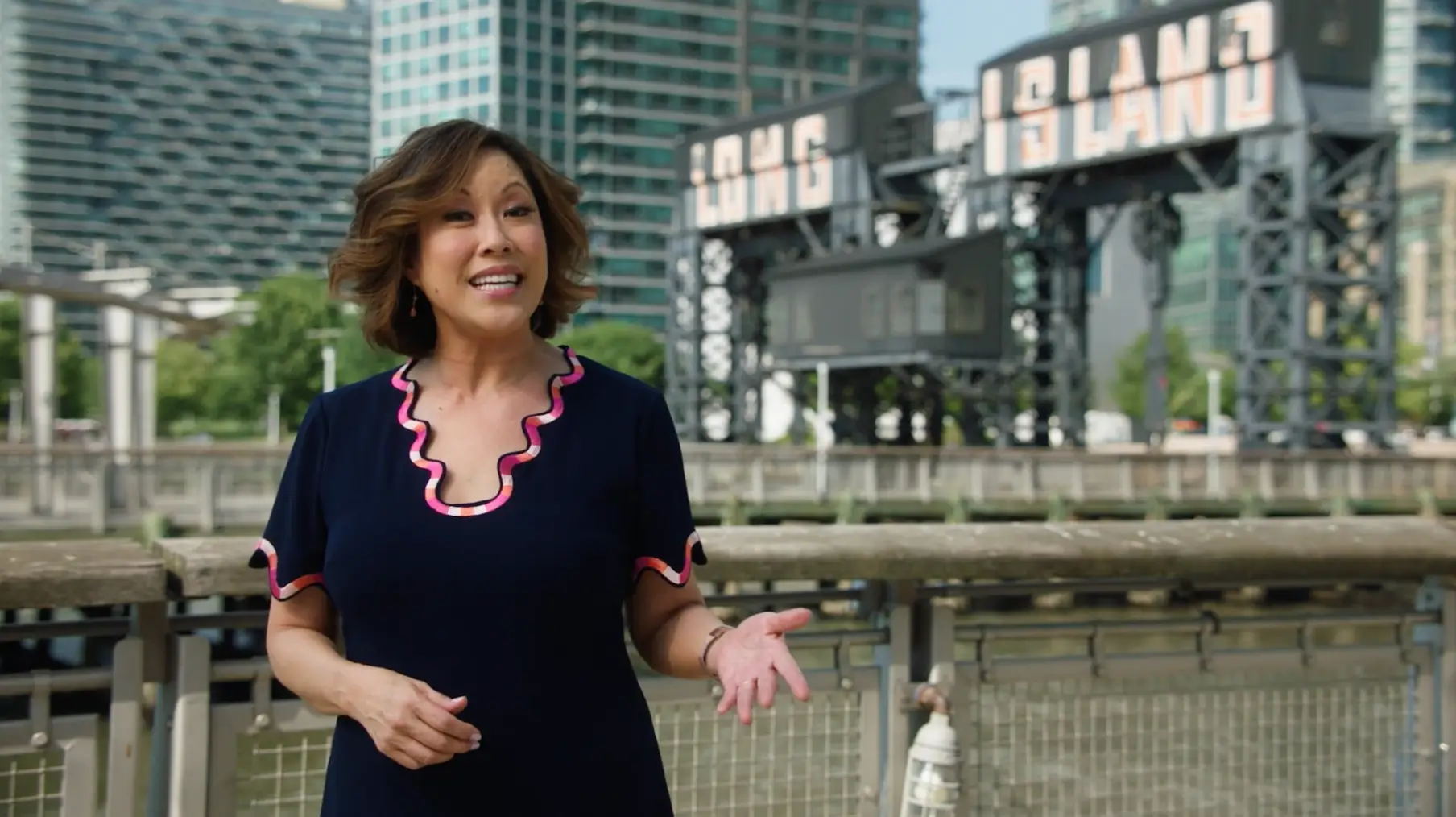 A woman in a blue dress standing in front of a city for the CBS News NY brand campaign.