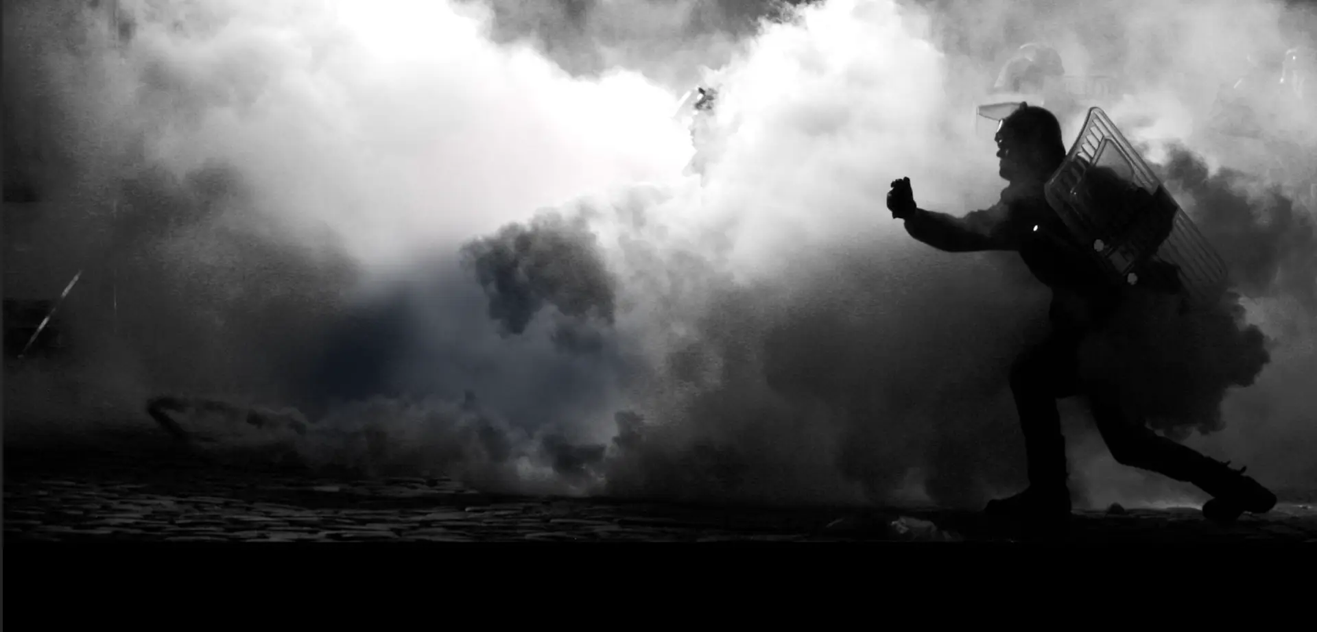 A black and white branded image of a man running through smoke, LIVE 2023.