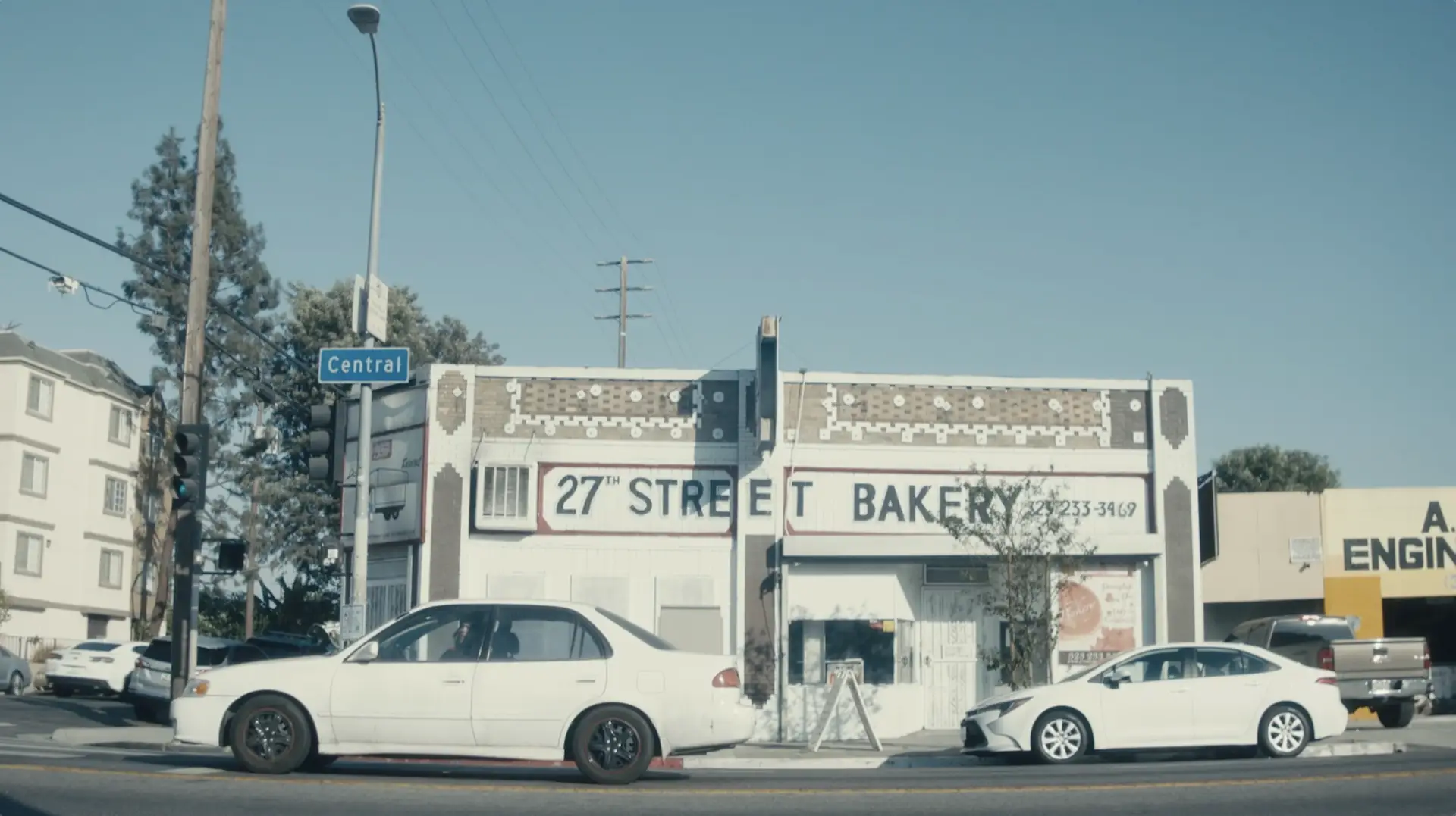 Two cars are parked in front of a bakery, their purchases empowered by grants from PayPal.