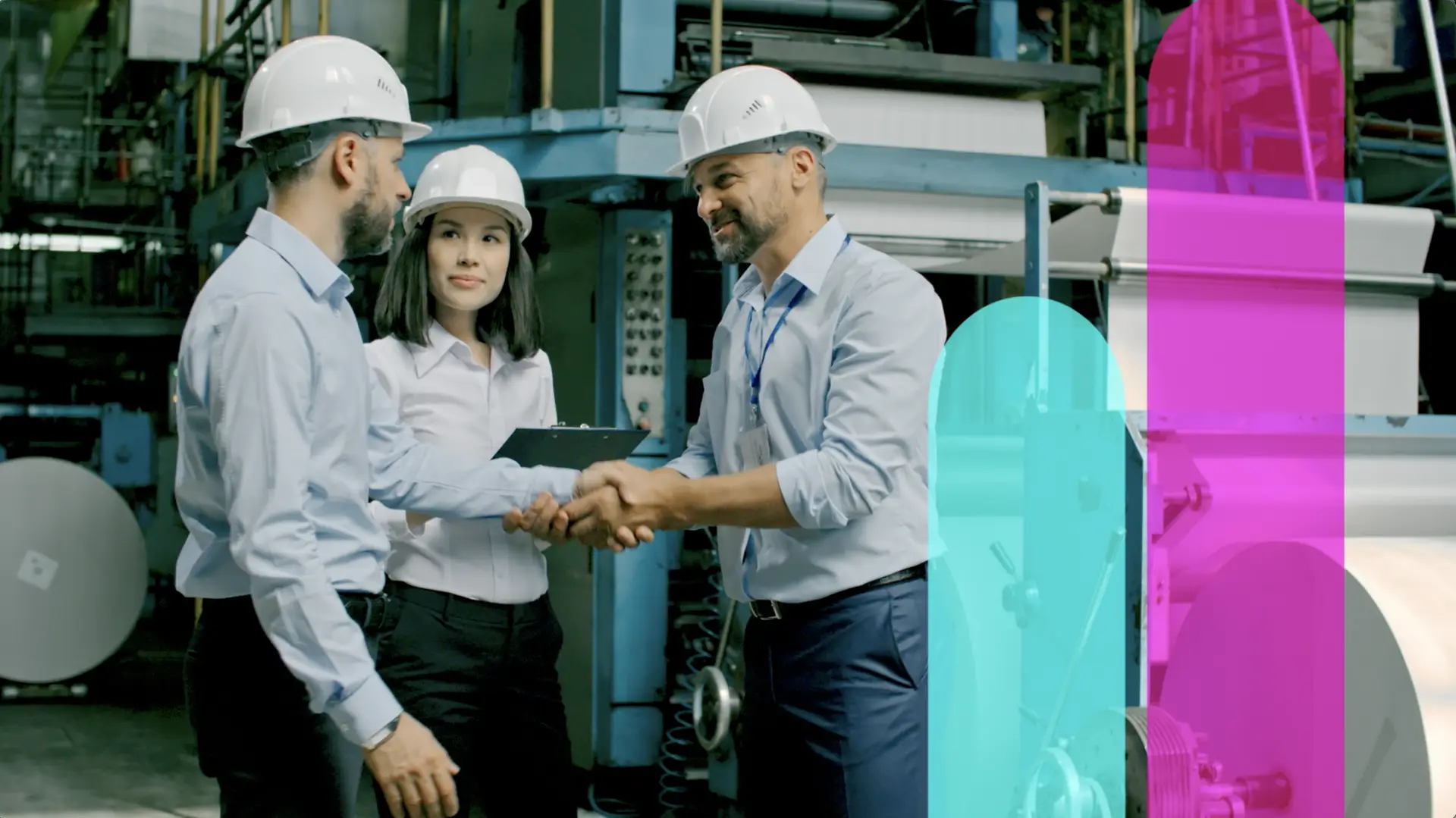Three people shaking hands in front of a factory, symbolizing a great work culture.