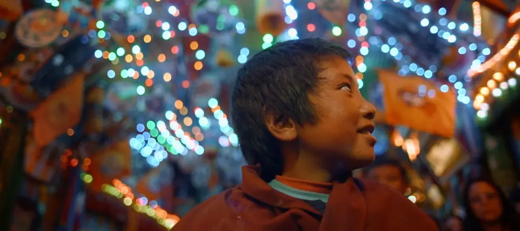 A boy is standing in front of a lot of lights, capturing live content that inspires.