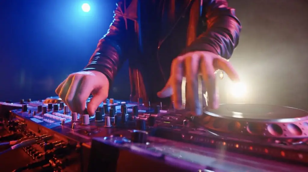 A DJ is mixing music on a turntable using Rockbot, a business music solution.