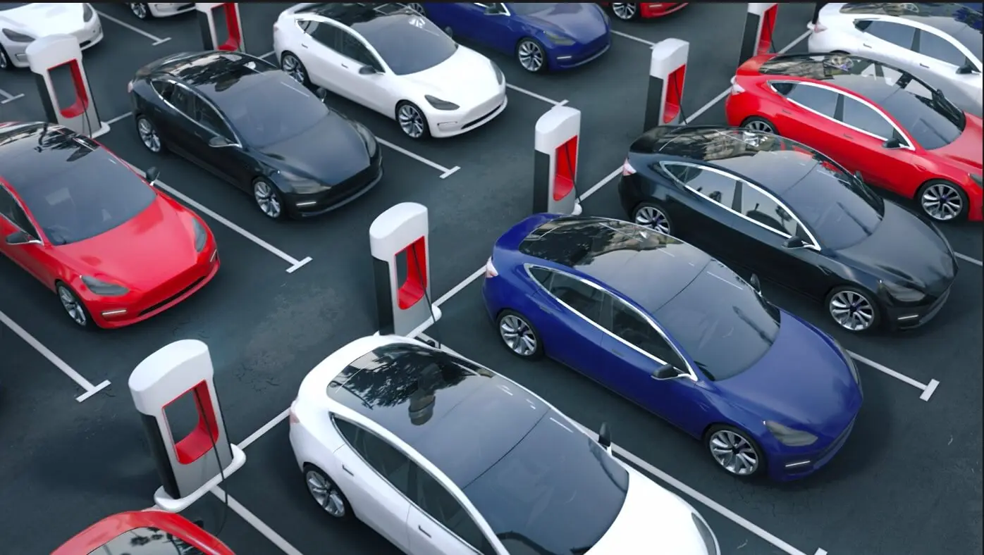 A group of Tesla cars parked in a parking lot.