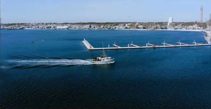 An aerial view of a boat docked in a harbor, LIVE 2023.