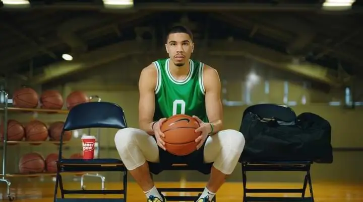 A man sitting on a chair holding a basketball, LIVE 2023.