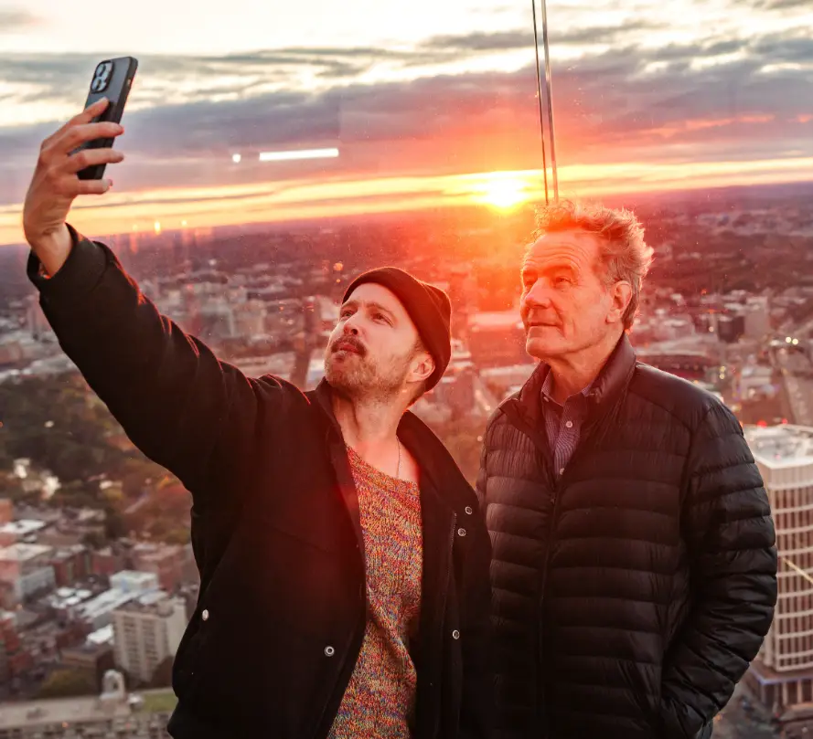 Two men are taking a selfie on the top of a building in Boston.