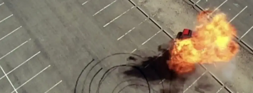 Explosion erupts from a manhole cover on a city street, showering debris.